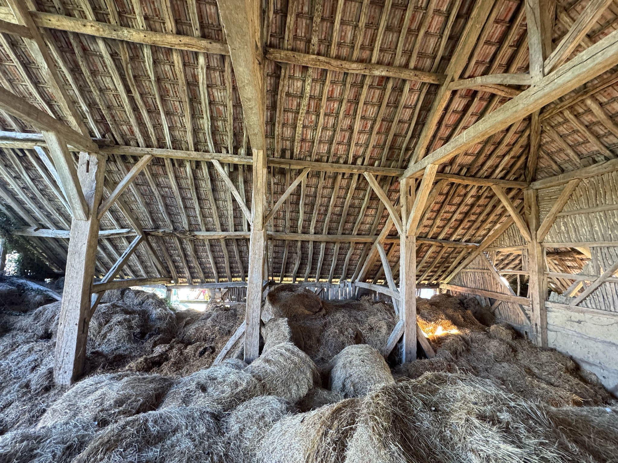 Interior of the original 1487 barn in France — oak timbers, hand-shaped over centuries.